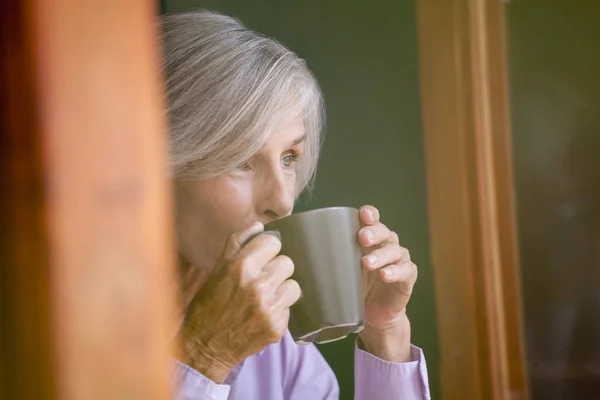 Oudere vrouw die koffie drinkt — Stockfoto