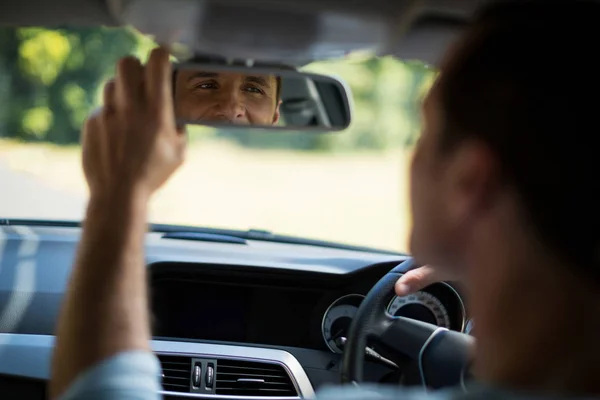 Человек регулирует зеркало в машине — стоковое фото