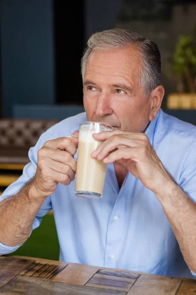 Sênior pensativo homem segurando café frio — Fotografia de Stock