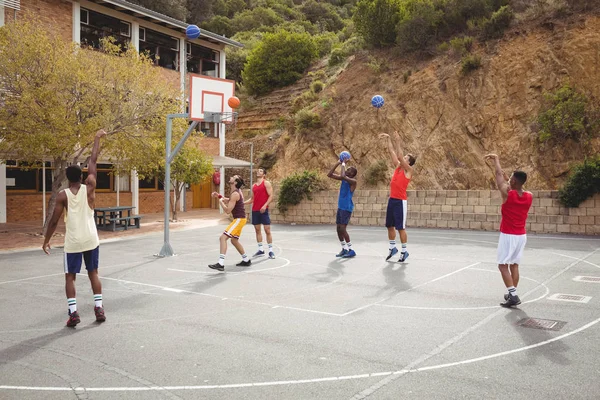 Jogadores de basquete praticando na quadra de basquete — Fotografia de Stock