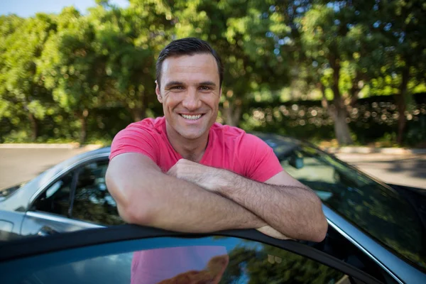 Sonriente hombre apoyado en el coche — Foto de Stock