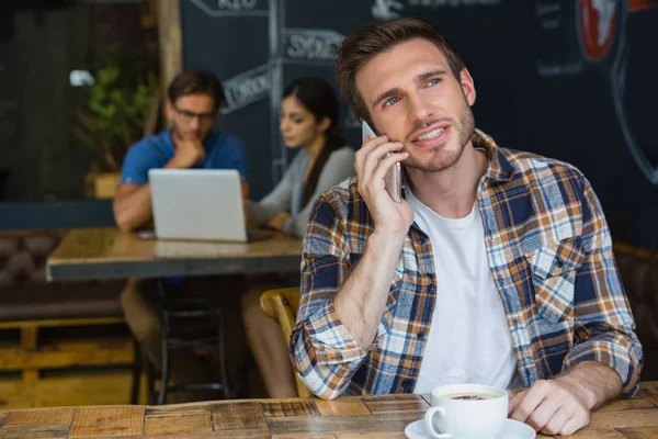 Homem falando no celular enquanto toma café — Fotografia de Stock