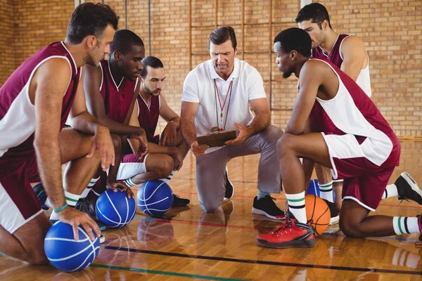 Treinador explicando plano de jogo para jogadores de basquete — Fotografia de Stock