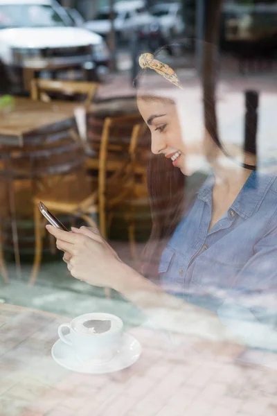 Kvinna med mobiltelefon på café butik — Stockfoto