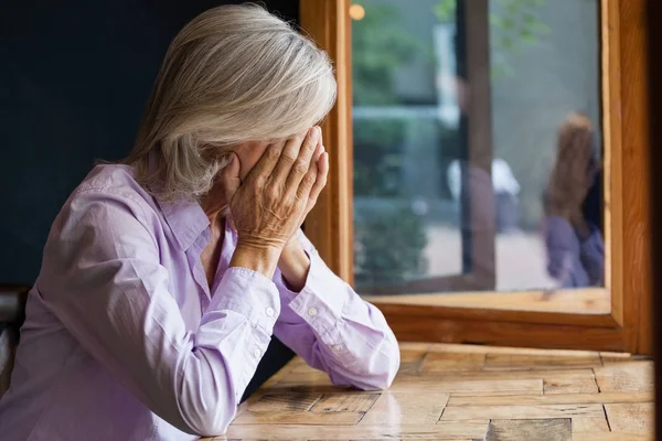 Senior vrouw bedekking gezicht — Stockfoto