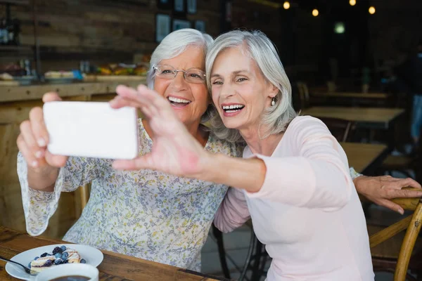 Twee senior vrouwen nemen selfie vanaf telefoon — Stockfoto