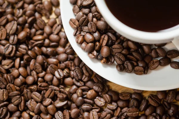 Coffee beans with cup on table — Stock Photo, Image