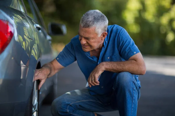 Mann kontrolliert Lenkrad von Auto auf Straße — Stockfoto