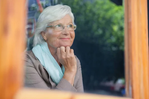 Senior vrouw op zoek weg in café winkel — Stockfoto