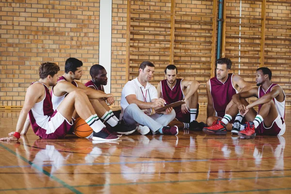 Coach explicando el plan de juego a los jugadores de baloncesto —  Fotos de Stock