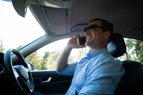 Man talking on phone driving car — Stock Photo, Image