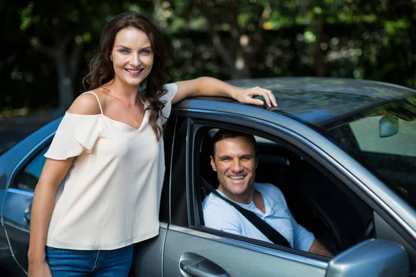 Mulher inclinada enquanto homem sentado no carro — Fotografia de Stock