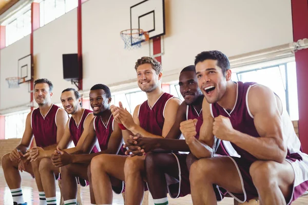 Emocionado jugador de baloncesto sentado en el banco —  Fotos de Stock