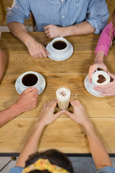 Друзья пьют кофе за столом — стоковое фото