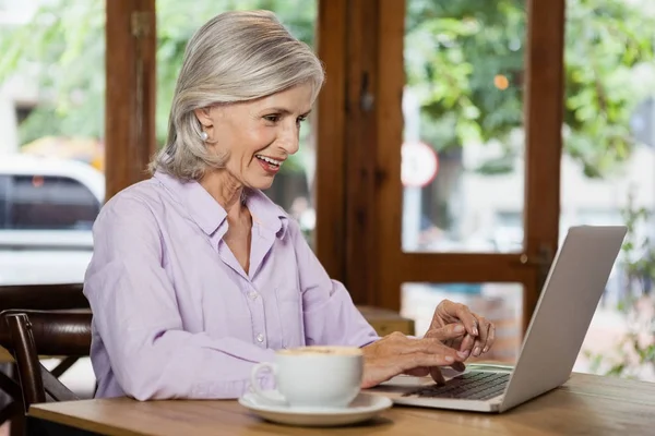 Senior vrouw met behulp van laptopcomputer — Stockfoto