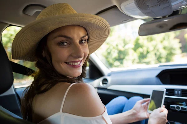 Молодая женщина с телефоном в машине — стоковое фото