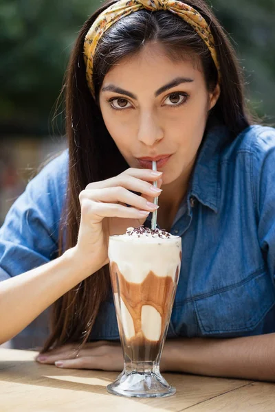 Woman drinking cold coffee at table — Stock Photo, Image