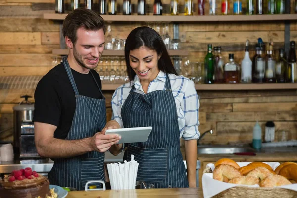 Waiter and waitresses using tablet at counter — Stock Photo, Image