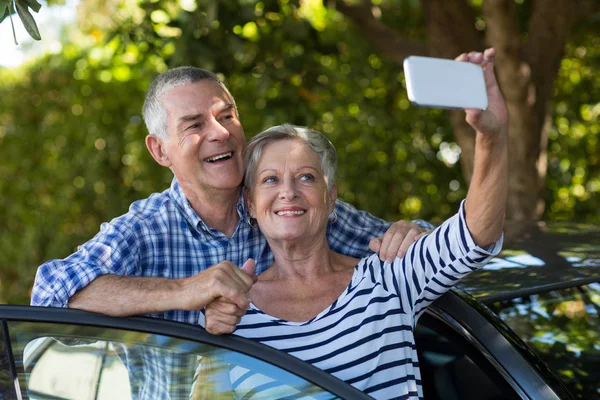 Coppia anziana prendendo selfie in auto — Foto Stock