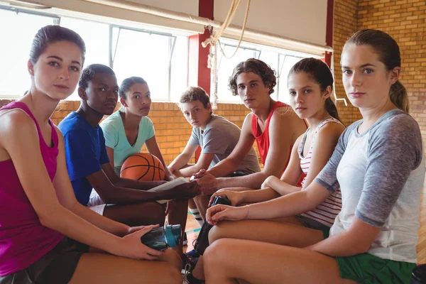 Middelbare schoolkinderen ontspannen in basketbalveld — Stockfoto