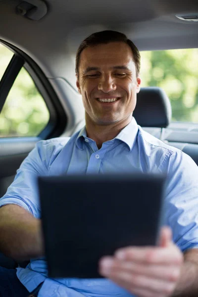 Homme utilisant une tablette numérique en voiture — Photo