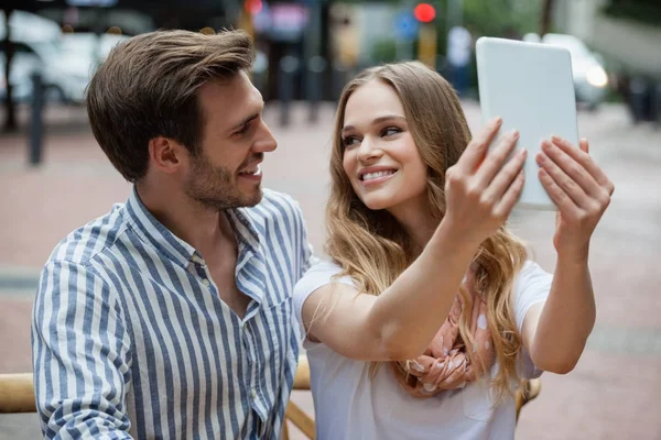 Couple holding tablet while sitting at cafe — Stock Photo, Image