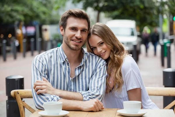 歩道のカフェに座って笑顔のカップル — ストック写真