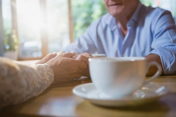 Äldre par hålla händerna samtidigt ha kaffe — Stockfoto