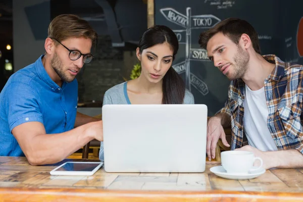 Friends using laptop while having coffee — Stock Photo, Image