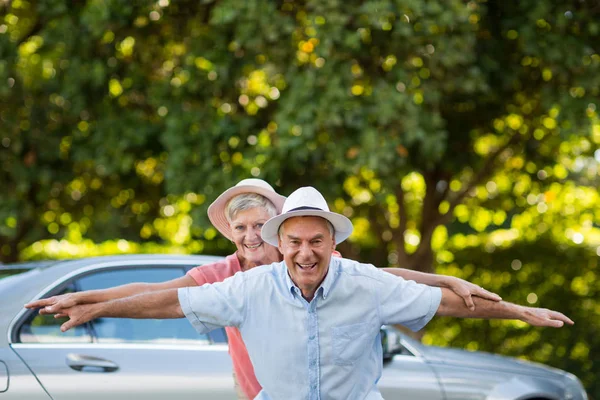 Carefree senior couple enjoying by car — Stock Photo, Image