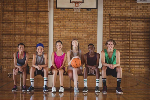 School kids on a bench in basketball court — Stock Photo, Image