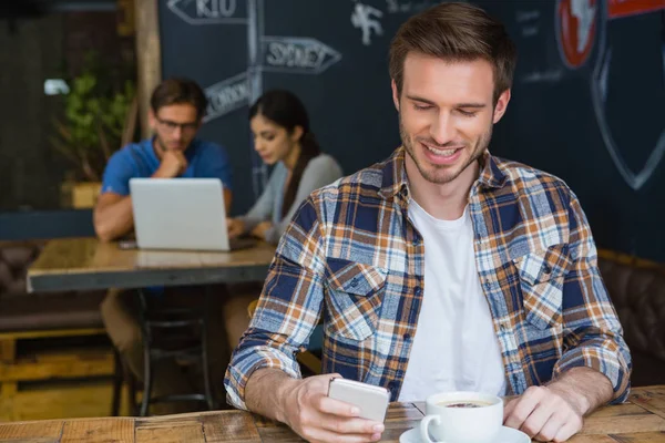 Hombre usando el teléfono móvil mientras toma café —  Fotos de Stock