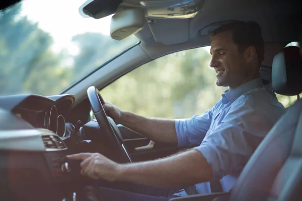 Homme souriant conduisant une voiture — Photo