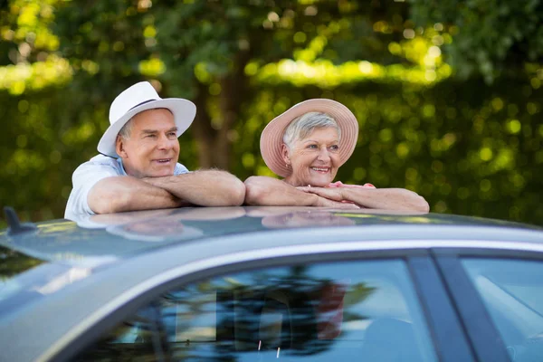 Coppia anziana appoggiata sul tetto dell'auto — Foto Stock