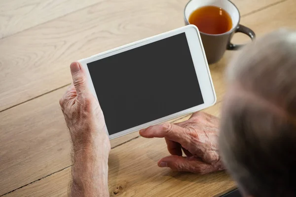 Man using tablet while sitting at table — Stock Photo, Image
