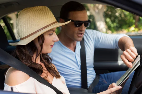 Pareja leyendo mapa en coche — Foto de Stock