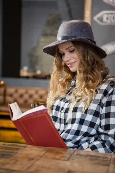 Woman wearing hat reading book — Stock Photo, Image
