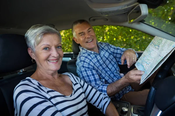 Coppia senior con cartina stradale in auto — Foto Stock