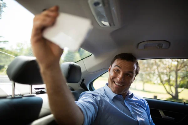 Homem tomando selfie enquanto sentado no carro — Fotografia de Stock