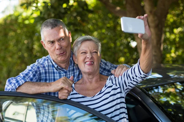 Lekfull äldre par med selfie — Stockfoto