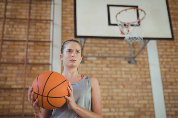 Entschlossenes Mädchen mit einem Basketballkorb — Stockfoto