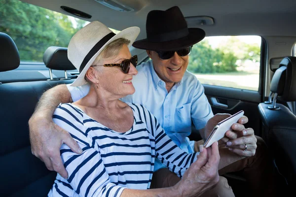 Coppia anziana scattare selfie sul sedile posteriore dell'auto — Foto Stock