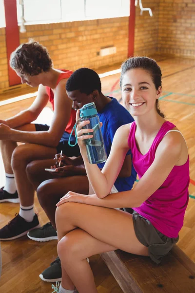 Lächelnde Gymnasiastin sitzt auf Bank — Stockfoto