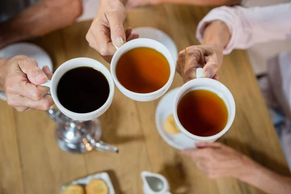 Grupo de amigos mayores tostando tazas de café — Foto de Stock