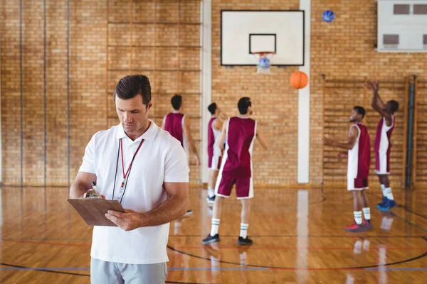 Treinador de basquete escrevendo na área de transferência — Fotografia de Stock