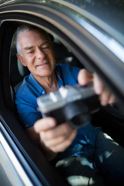 Старший мужчина делает селфи в машине — стоковое фото