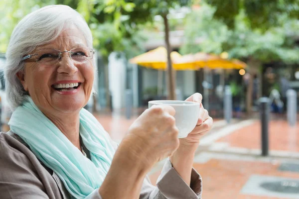 Senior mulher segurando uma xícara de café — Fotografia de Stock