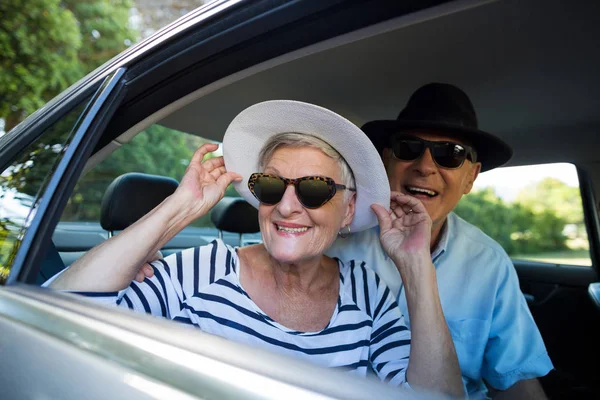 Casal sênior olhando pela janela do carro — Fotografia de Stock