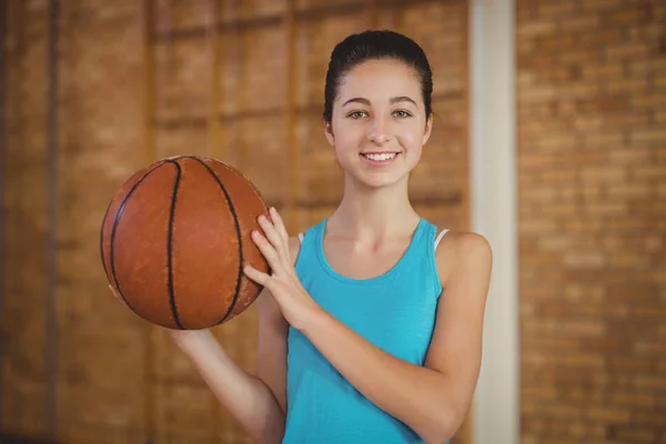 Усміхнена дівчина тримає баскетбол — стокове фото