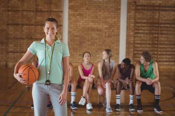 Ženské trenér stojí s basketbal — Stock fotografie